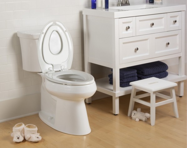 Next Step 2 built in potty seat in a bathroom setting next to white vanity and child step stool
