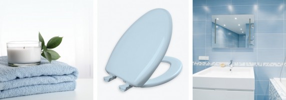 Stack of towels topped by small candle, blue plastic Bemis toilet seat, blue bathroom with white sink and tub