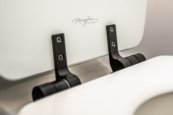 Closeup of black hinges on Mayfair wood toilet seat