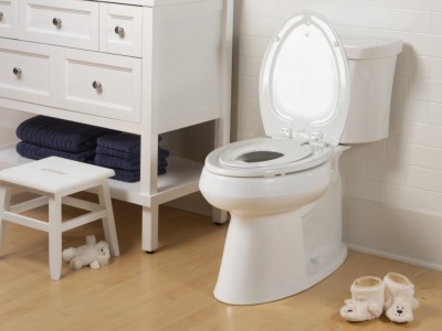 Mayfair by Bemis Next Step Two built in potty seat in bathroom next to small white vanity