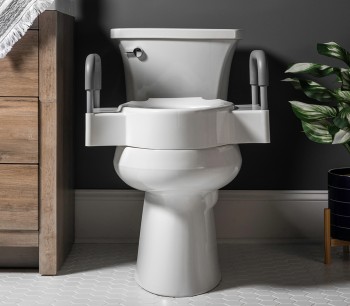 Lifestyle image of the Rise elevated seat on the toilet in a bathroom setting. 