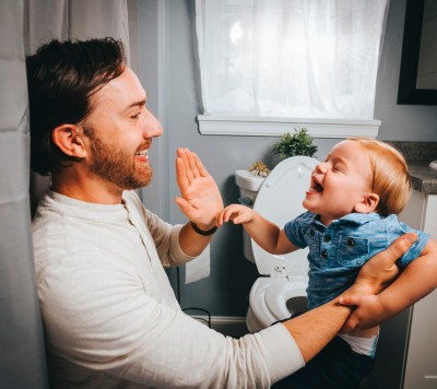 Father and small boy in the bathroom doing a high five